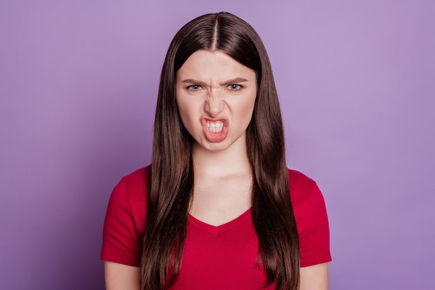 Portrait of angry mad aggressive woman look camera grin teeth on purple background