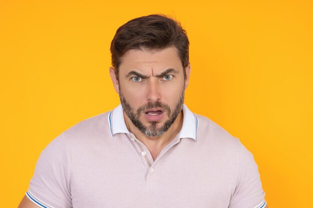 Photo portrait of angry man screaming portrait of young angry man isolated on yellow background angry male