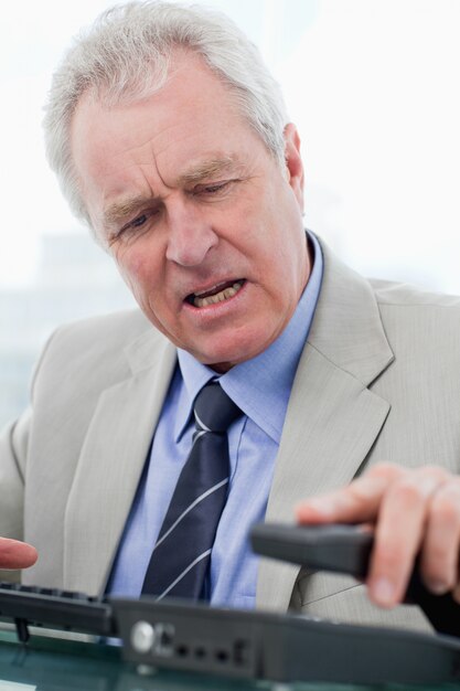 Portrait of an angry senior manager hanging up