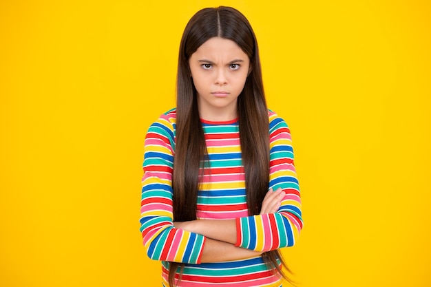 Portrait of angry teen girl looking at camera isolated on studio background Unhappy upset teenager child