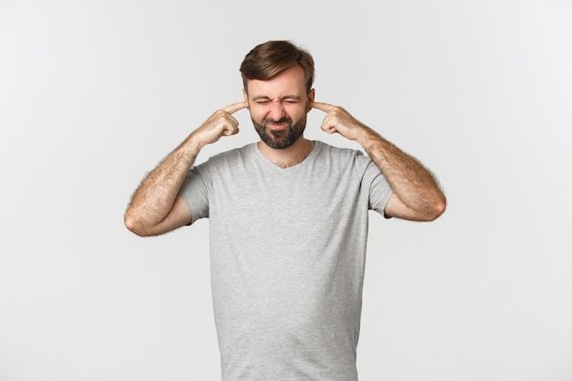 Portrait of annoyed guy in gray t-shirt