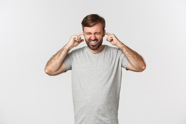 Portrait of annoyed guy in gray t-shirt