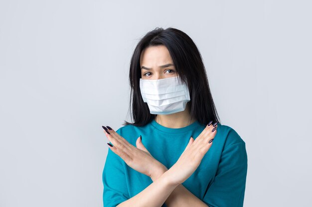 불안한 우울한 소녀의 초상화는 covid19에 대한 두려움을 느끼고 회색 위에 고립 된 의료 마스크를 착용