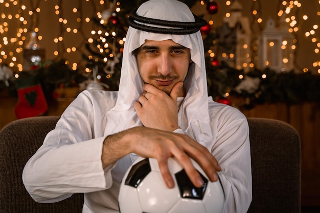 Foto ritratto di un uomo d'affari arabo che mostra una palla da calcio davanti - concetti campionati in qatar 2022