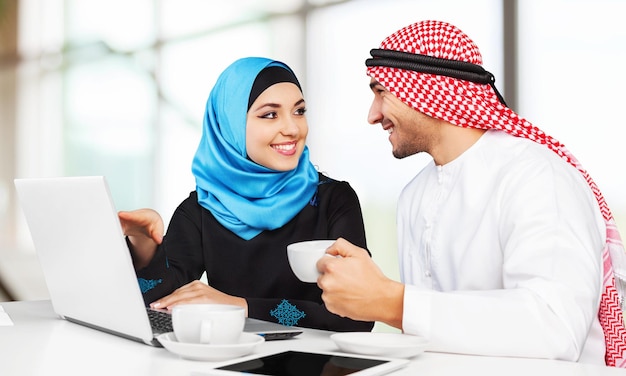 Portrait of arab couple with laptop on  background