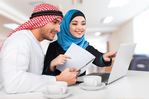 Portrait of arab couple with laptop on  background