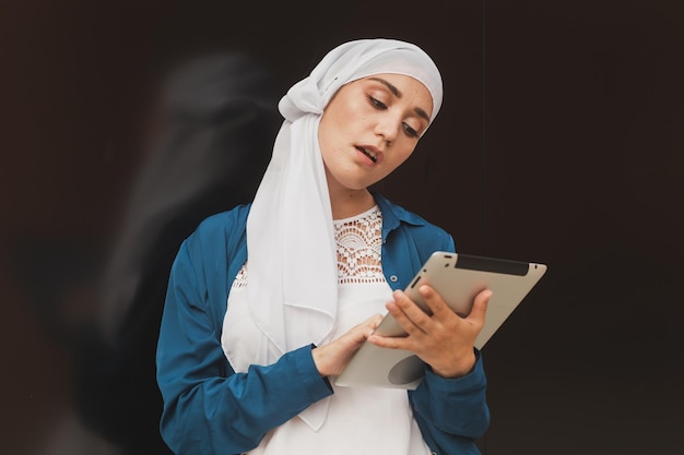 Portrait of an arab student girl holding a tablet arab business woman in hijab holding a tablet in