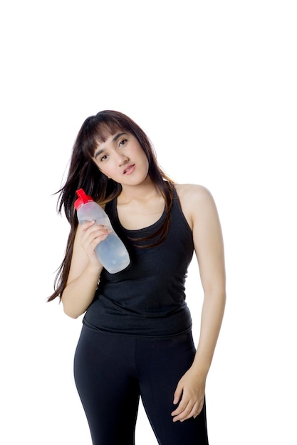 Photo portrait of arabian girl wearing sportswear while holding a water bottle, isolated on white background