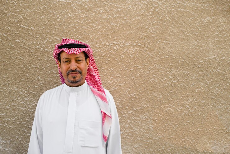 Photo portrait of an arabic man with a plain beige wall background