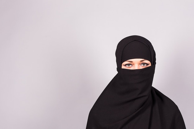 Ritratto di una giovane donna araba con i suoi bellissimi occhi azzurri nel tradizionale panno islamico niqab.