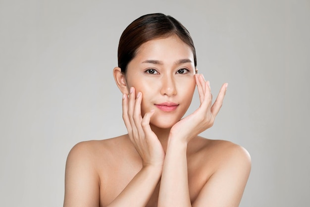 健康的な透明な肌と柔らかい化粧をした熱心な若い女性のポートレート、カメラを見て、美しさのジェスチャーをポーズ美容学のスキンケアと美しさのコンセプト