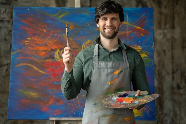 Portrait of an artist male is holding a brush