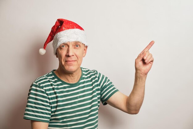 Portrait of asenior man in a santa hat on a white background copy space