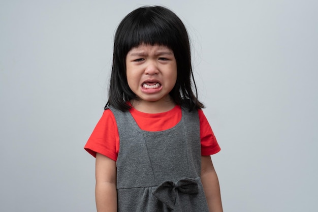 Photo portrait of asian angry sad and cry little girl on white isolated background the emotion of a child when tantrum and mad expression grumpy emotion kid emotional control concept