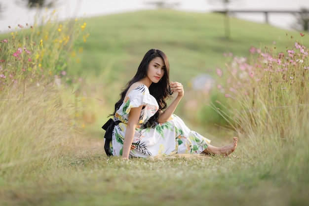 Portrait asian beautiful women sitting relax in the flower garden