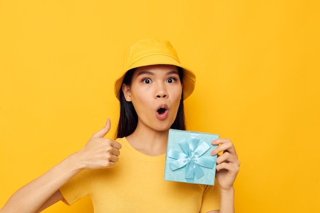 Portrait Asian beautiful young woman in a yellow Tshirt and a hat with a gift Lifestyle unaltered
