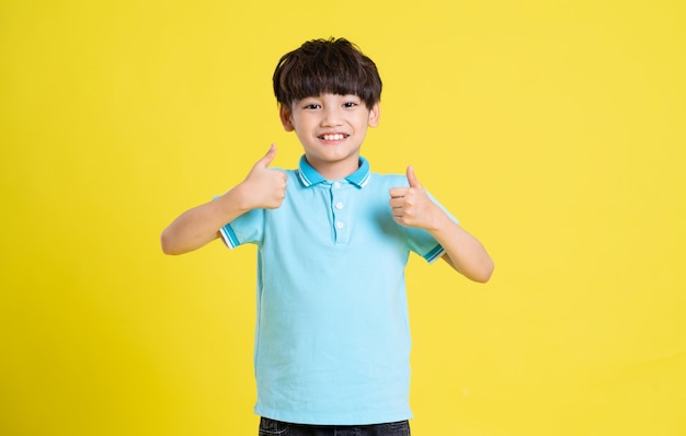 Portrait of an asian boy posing on a yellow background