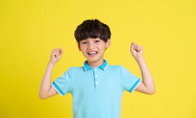 Portrait of an asian boy posing on a yellow background