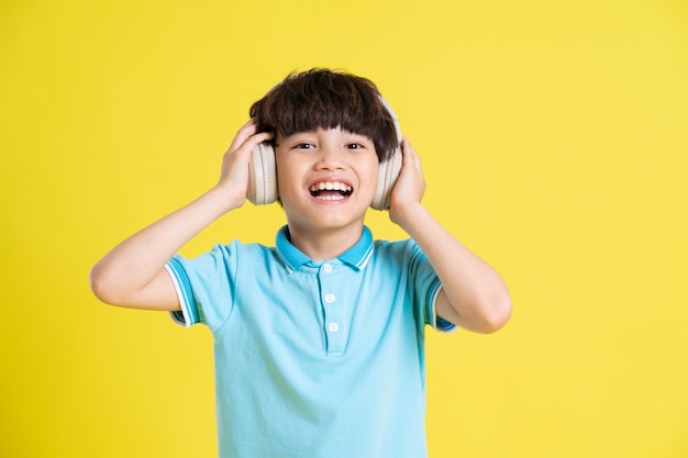 Portrait of an asian boy posing on a yellow background