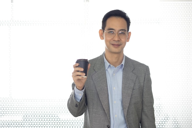 Портрет азиатского бизнесмена, стоящего перед камерой в современном офисе