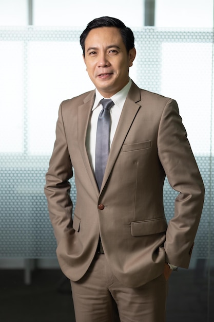 Portrait Asian business man standing look at camera in modern office