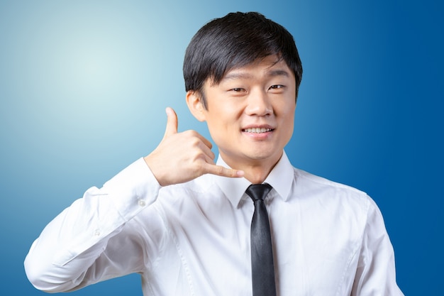 Portrait of an Asian businessman showing the 'call me' symbol