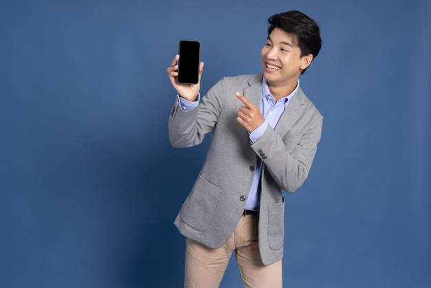 Portrait of Asian businessman showing isolated over blue background