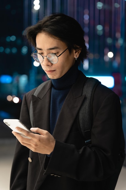 Portrait of an Asian businessman wearing a mask, in the street at night