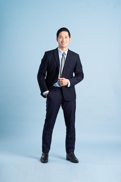 Portrait of asian businessman wearing suit on blue background