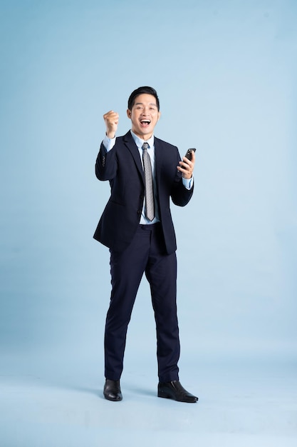 Портрет азиатского бизнесмена в костюме на синем фоне