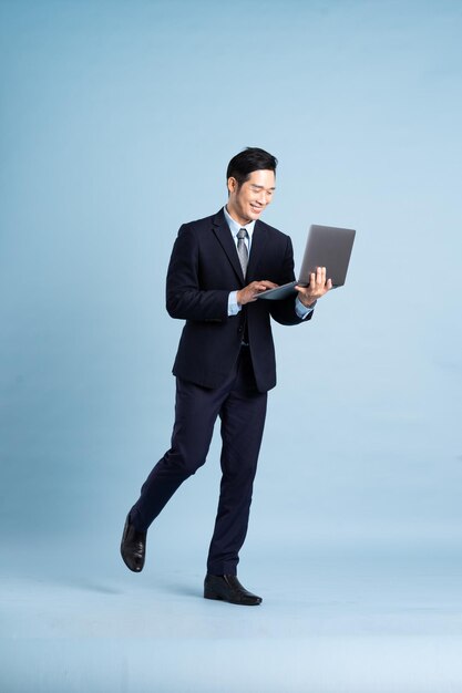 Photo portrait of asian businessman wearing suit on blue background