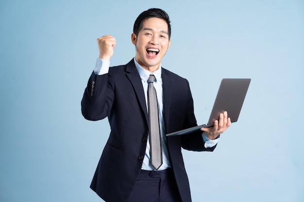 Portrait of asian businessman wearing suit on blue background