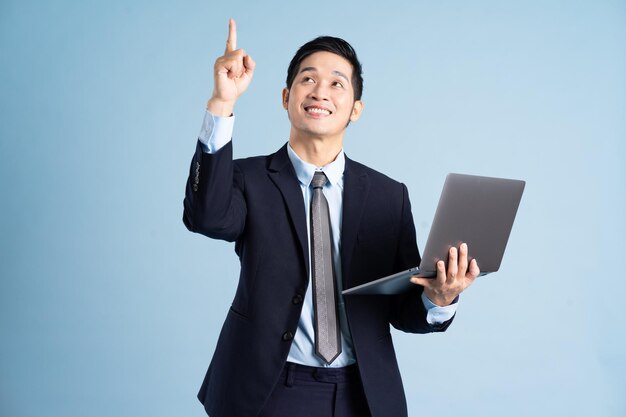 Photo portrait of asian businessman wearing suit on blue background