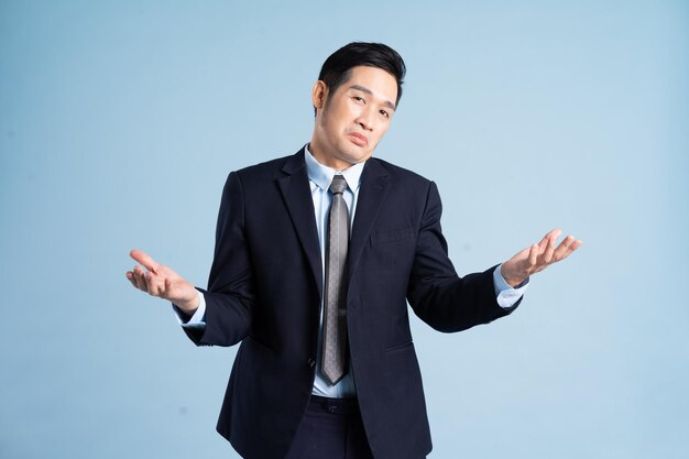 Portrait of asian businessman wearing suit on blue background