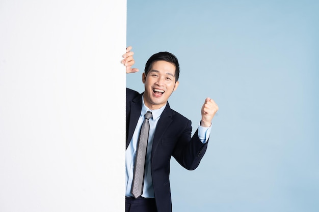 Portrait of asian businessman wearing suit on blue background