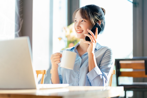 Ritratto di donna d'affari asiatica che lavora in un caffè