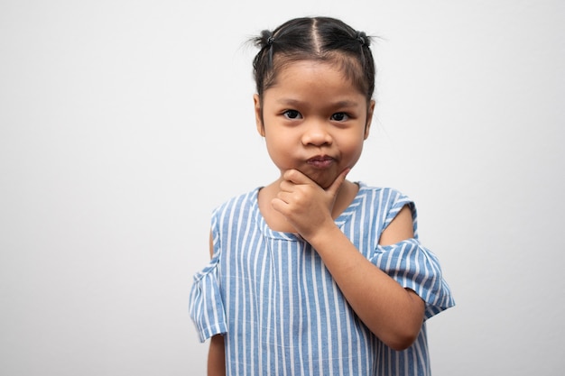 Портрет азиатского ребенка 5 лет и собрать волосы и положить руки ей на подбородок и принять позу размышления