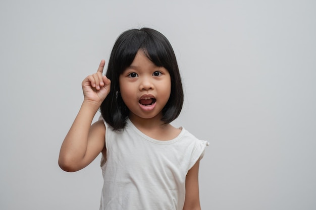 Portrait of Asian child 5 year old and to collect hair and Place her hands on her chin make thinking