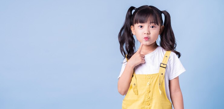 Photo 青い背景にポーズをとってアジアの子供の肖像画