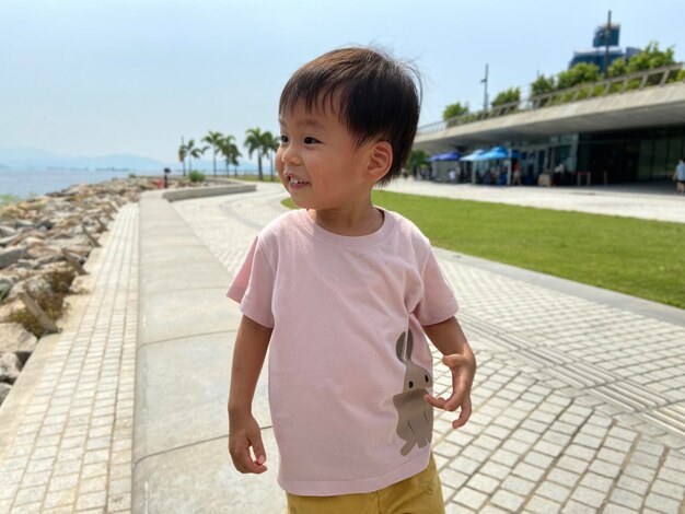 Photo portrait of asian cute boy standing on footpath