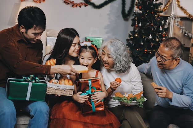 portrait of asian family exchanging presents during christmas at home attractive happy people holding gift box celebrate holiday thanksgiving xmas eve tradition in living room in house together