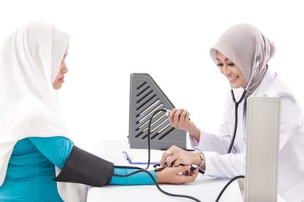 Portrait of asian female doctor checking blood pressure of a patient while smiling