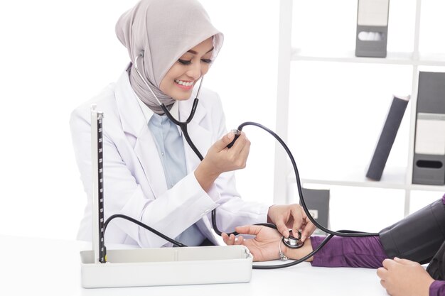 Portrait of asian female doctor checking blood pressure of a patient