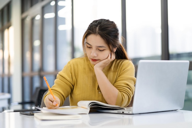 Photo portrait of asian female student studying at university library