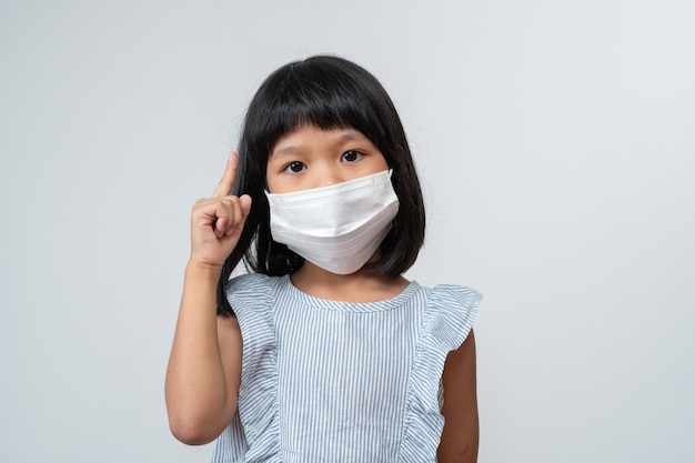 Portrait of asian girl kid with protective face mask ready to\
school year with pandemic restrictions