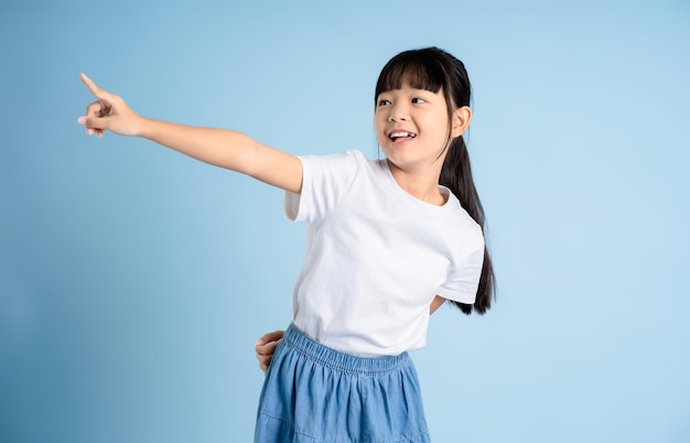 Portrait of Asian girl posing on blue background