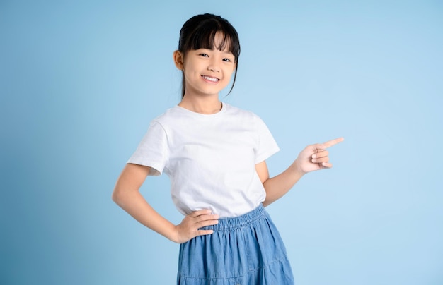 Portrait of Asian girl posing on blue background