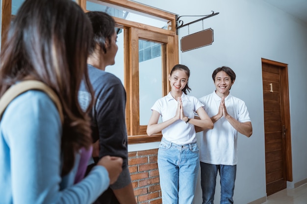 Portrait of asian guesthouse staff welcoming couple in boutique hotel