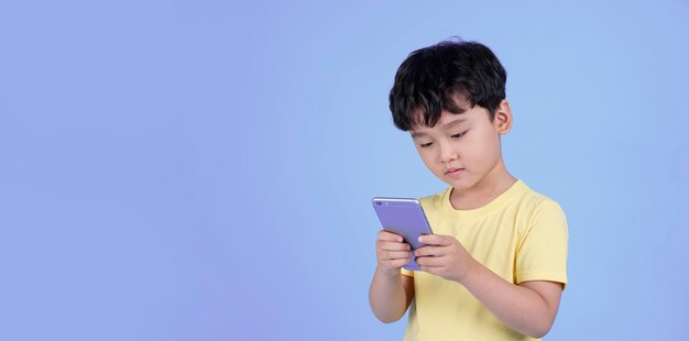 Portrait of Asian handsome little kid boy using smart phone i