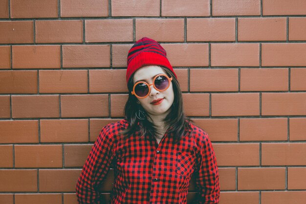 Portrait asian hipster girl on brick wall backgroundshe wear red hat vintage stylefashion conceptthailand people